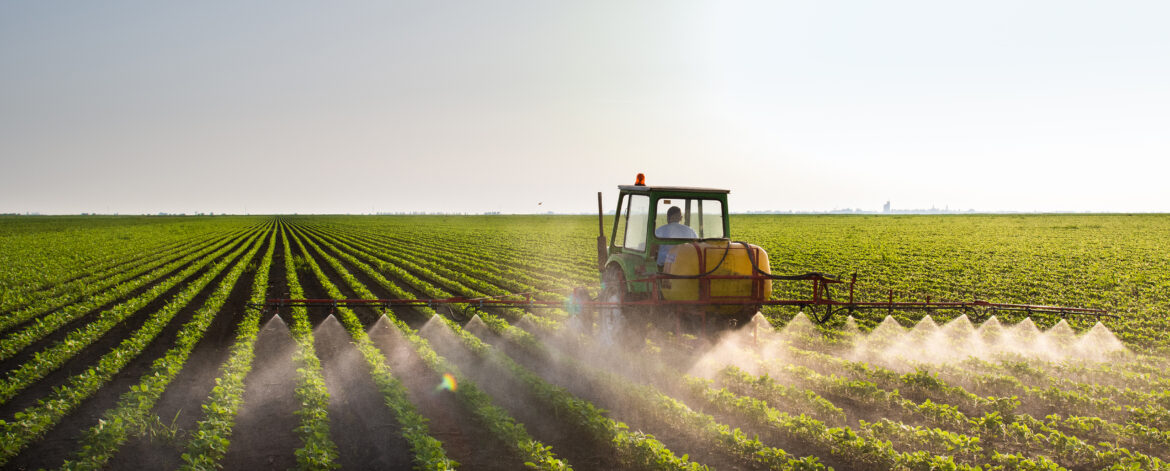 Tractor spraying soybean field